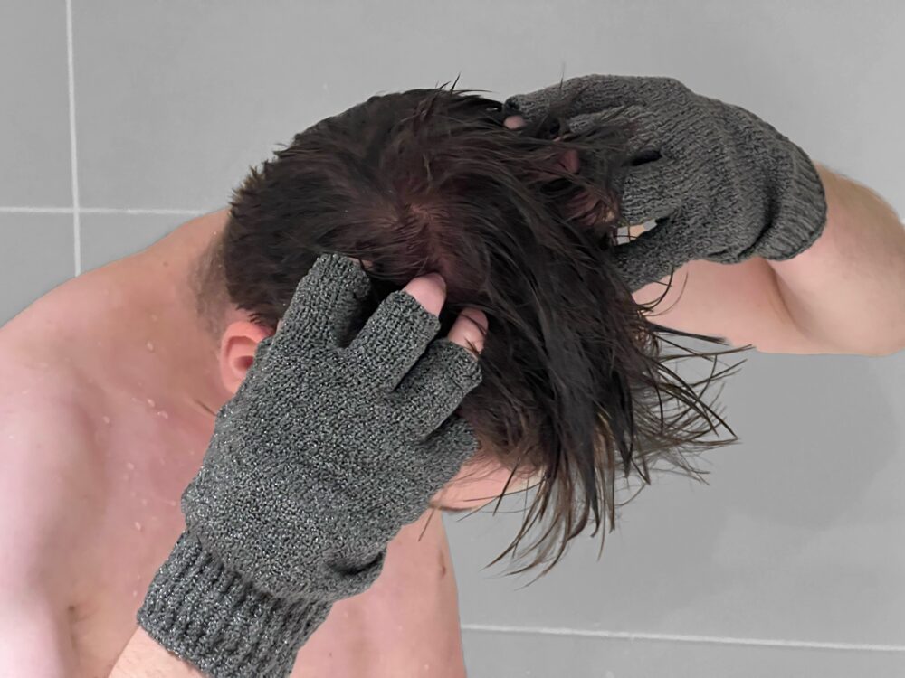 Person washing their hair while wearing a grey ESDA glove