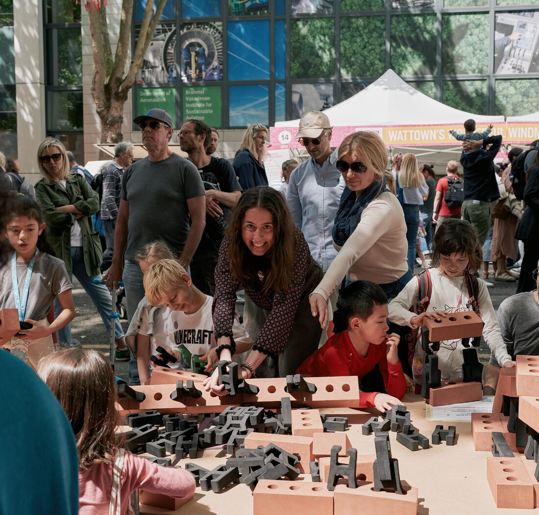 Magdalena helping children build with large foam blocks at a public event